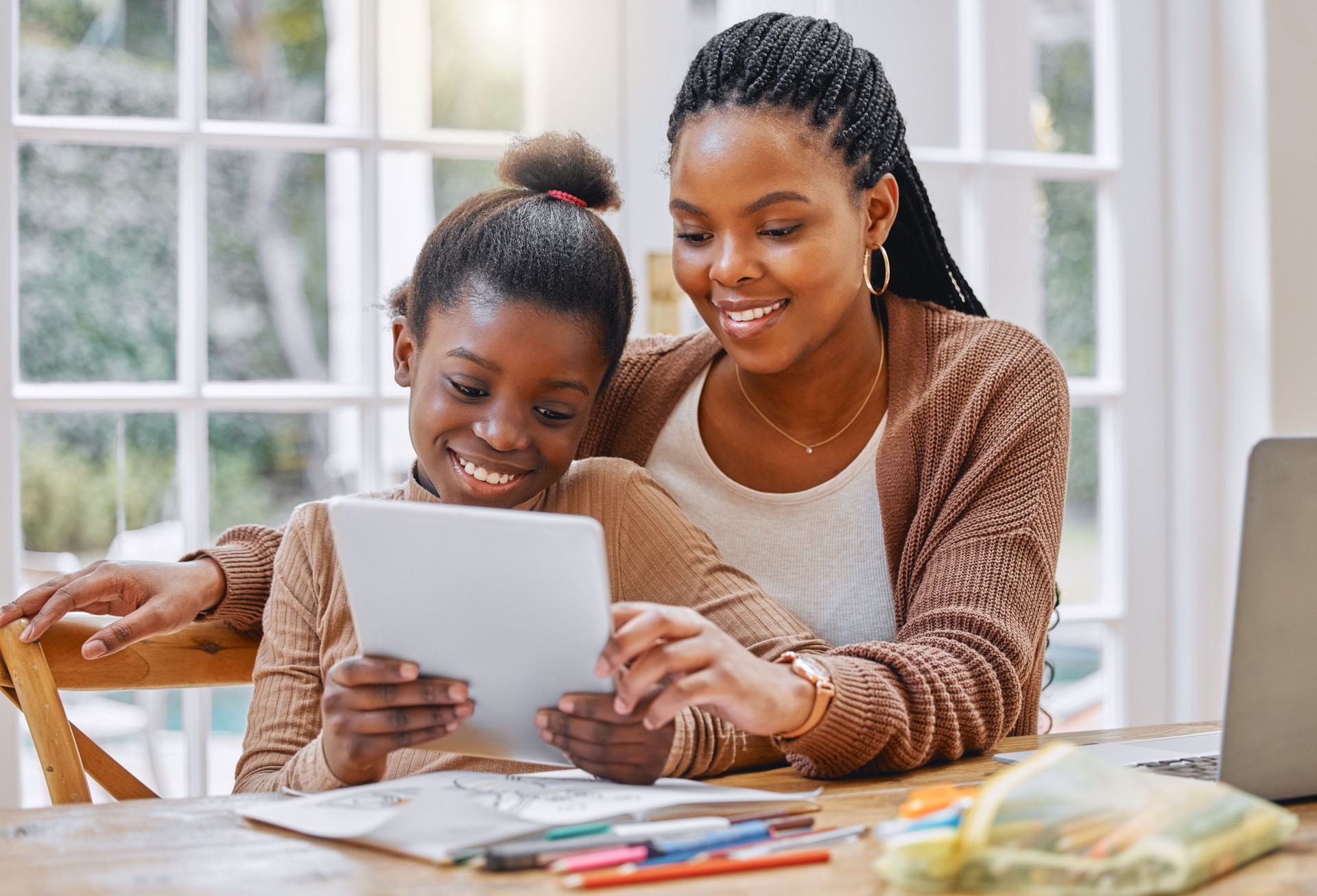 Foto de una joven madre e hija usando una tableta digital en casa